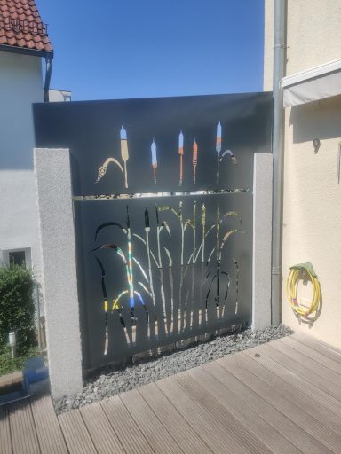 Moderne Metallkunst mit bunten Elementen, zeigt verschiedene Werkzeuge vor einem hellen Hintergrund.